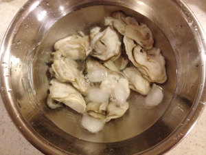 牡蠣を氷塩水で洗う